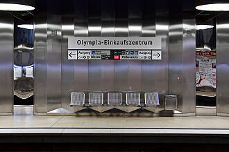 Sitzgruppe am Olympia-Einkaufszentrum mit angepasster Bahnsteigbeschriftung (2018)